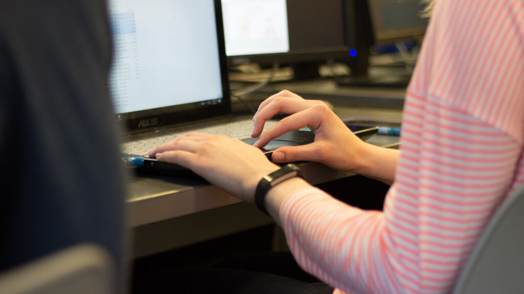 Student typing on her laptop during class