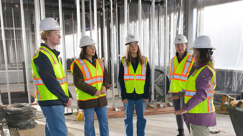 group of construction engineers talking as a group on site of a project