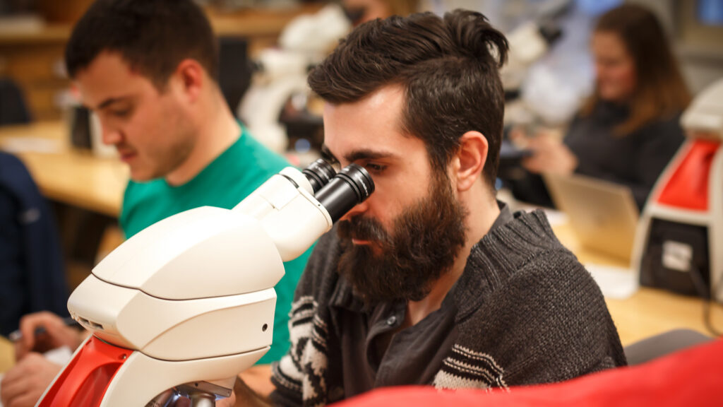 Student looking at something through a microscope
