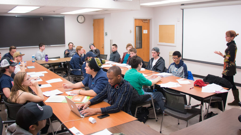 Students sitting in class listening to the professor.