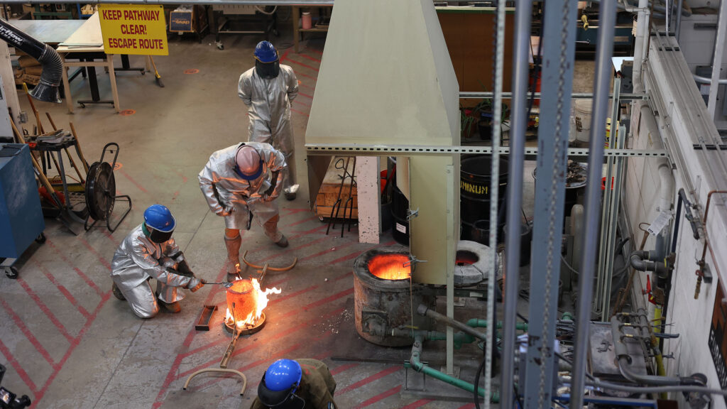 Students working with hot metals in a lab like setting