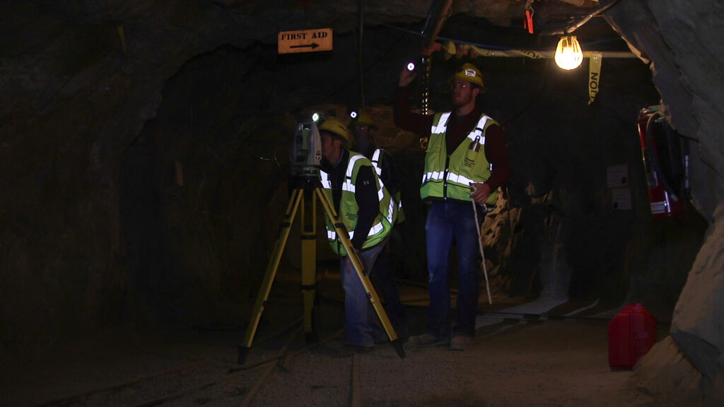 Students working with machinery inside a mine