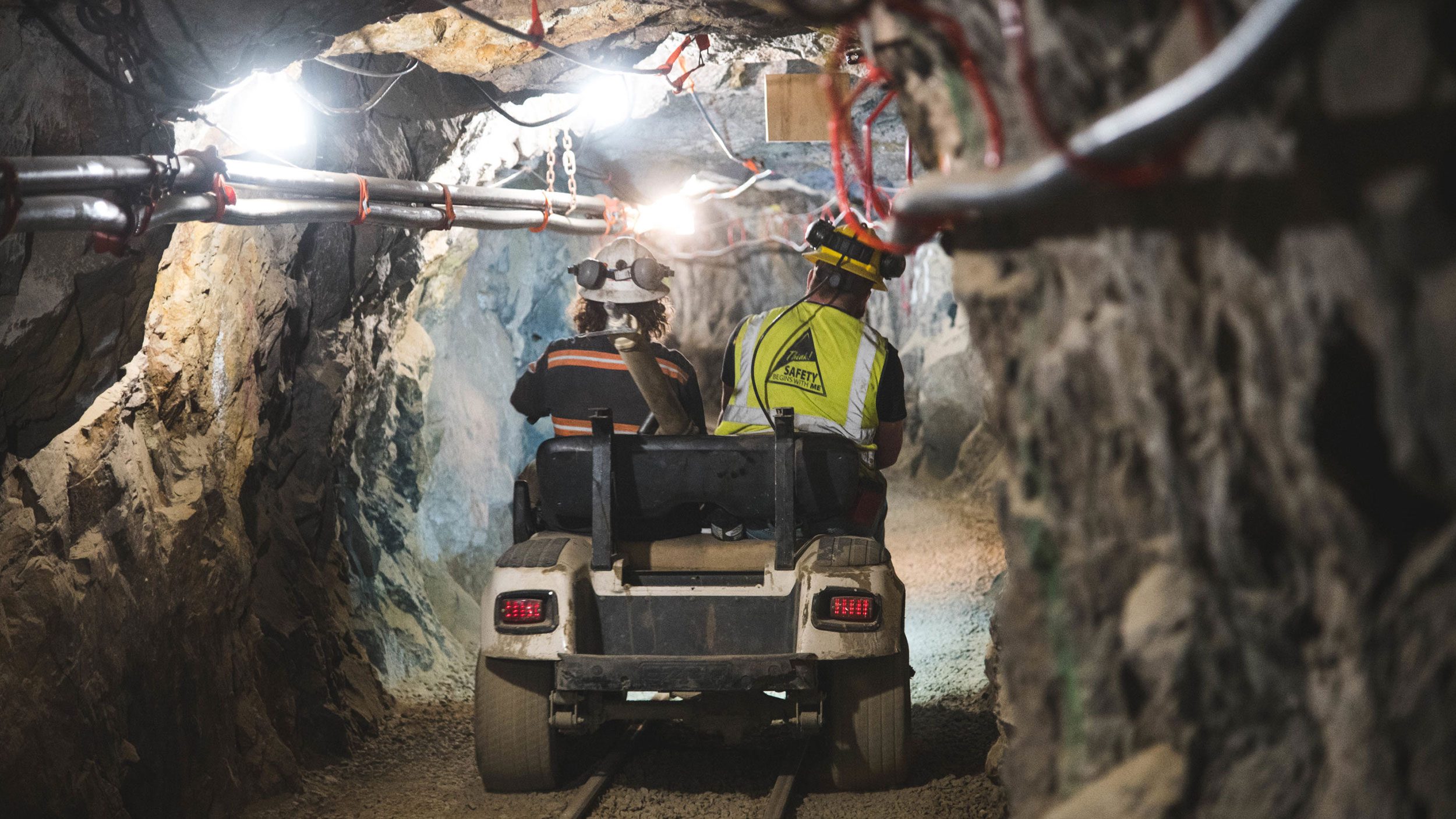Mine two engineers driving a cart through a mining tunnel
