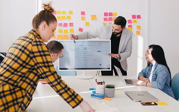 people working on a project in boardroom with whiteboard