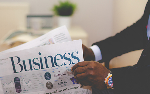 man holding business section of a newspaper