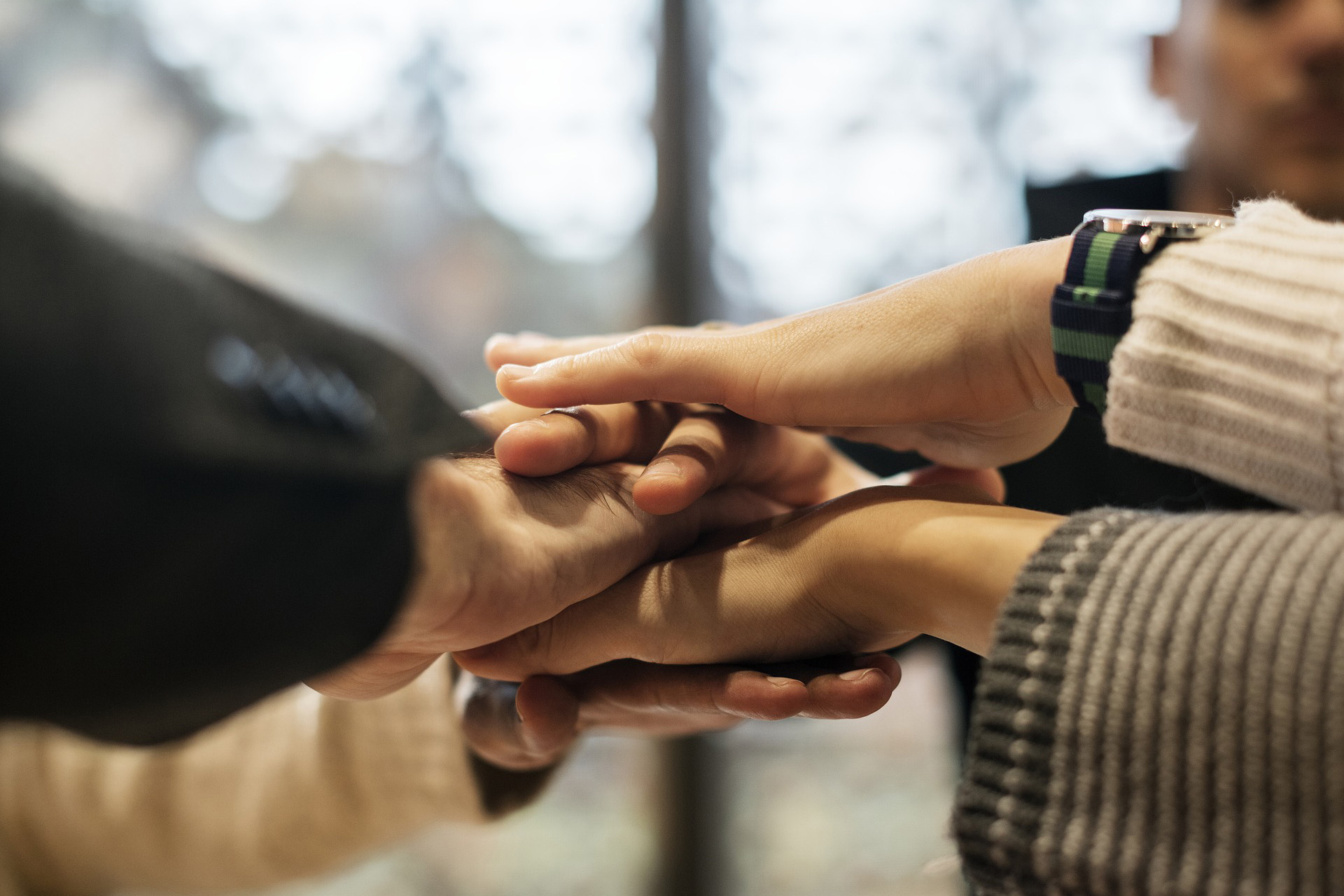 many hands embracing in the middle