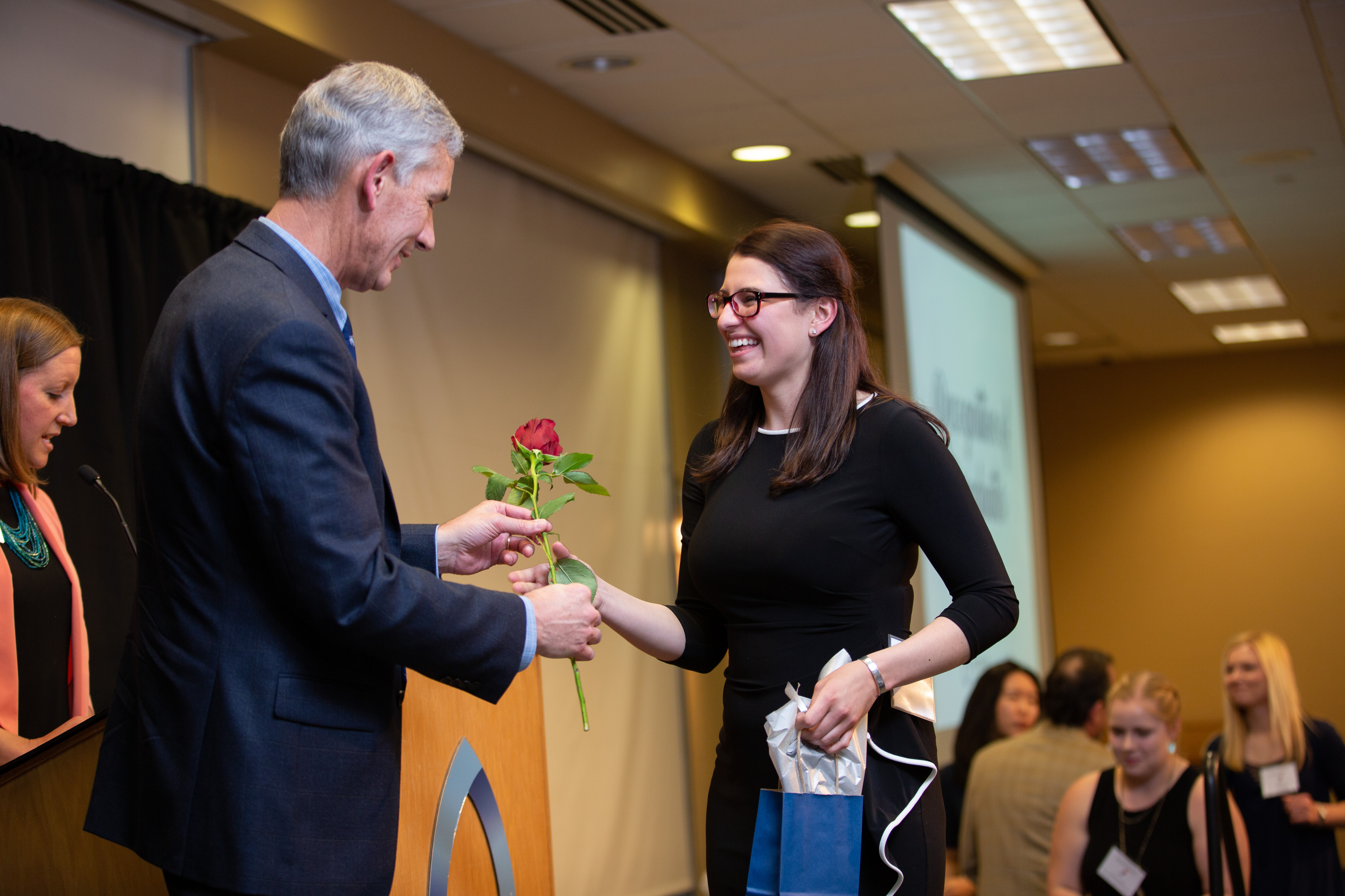 woman student receiving a rose from PCJ at continuum