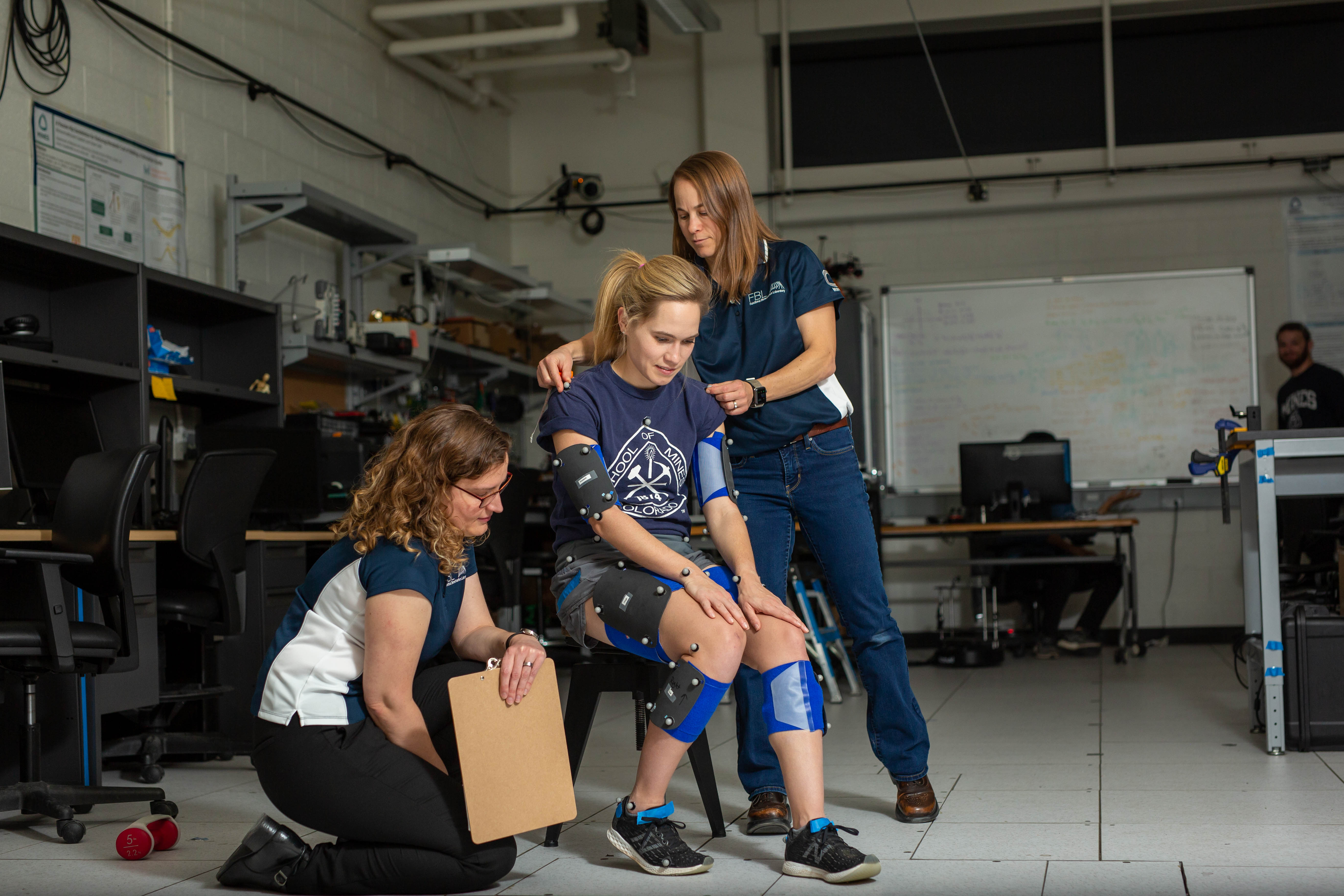 lab participant seated with sensor pads in biomechanics lab