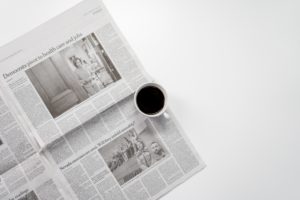 newspaper with a cup of copy sitting on top