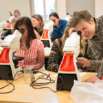 Instructor using a microscope with students