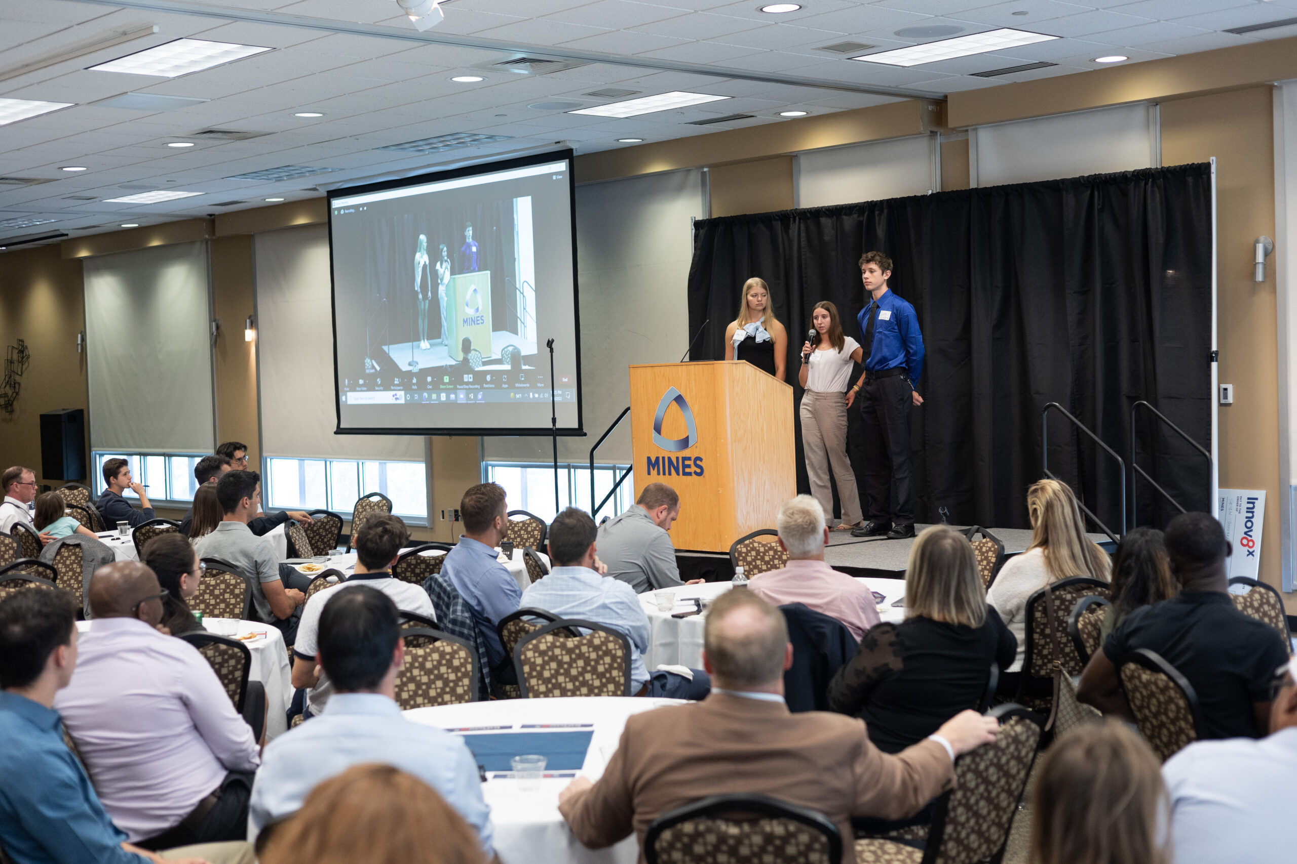 Students on a stage, presenting to an audience