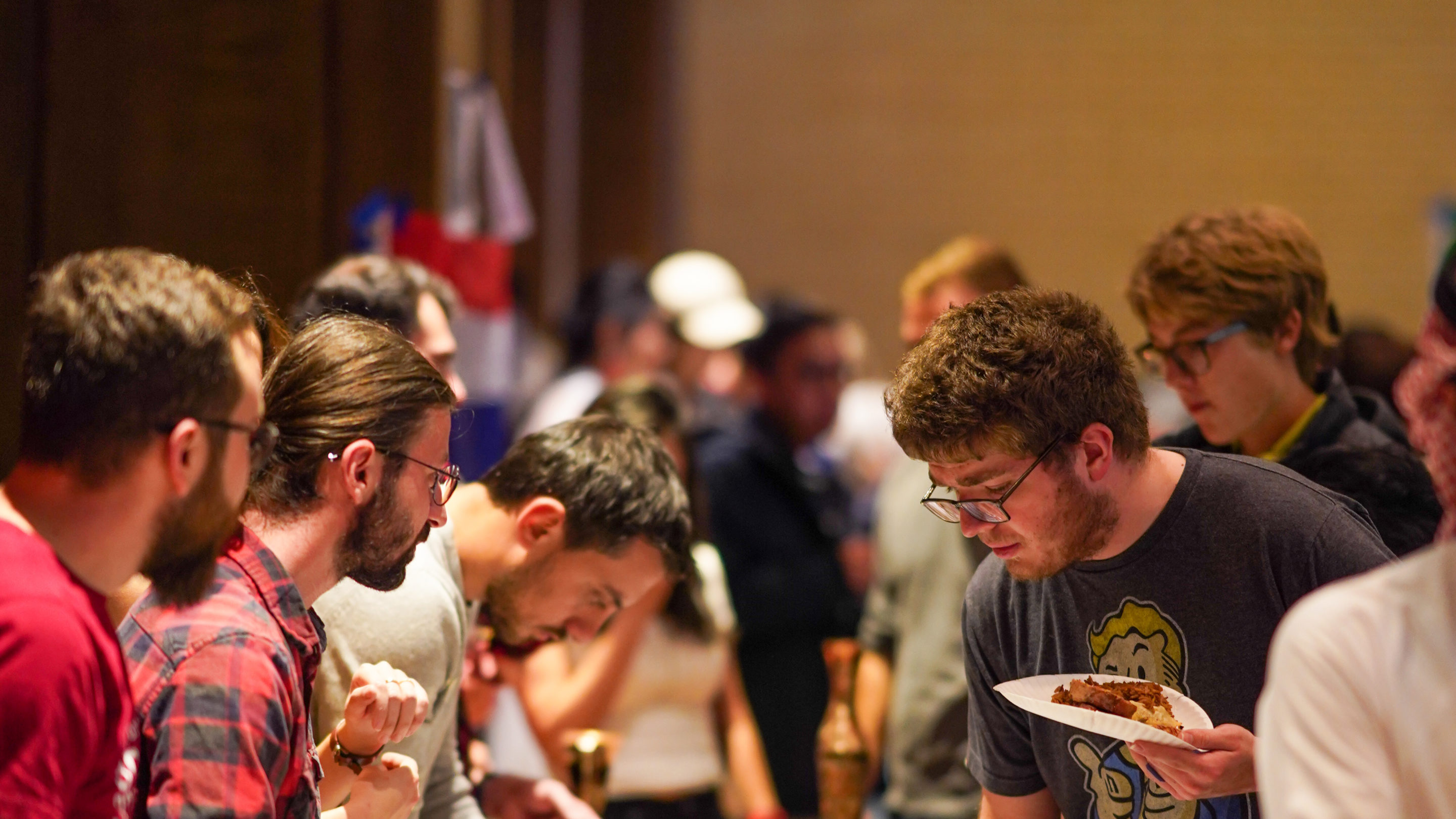 Navigates to the Prospective Students page. An image of students eating food at the International Day celebration.