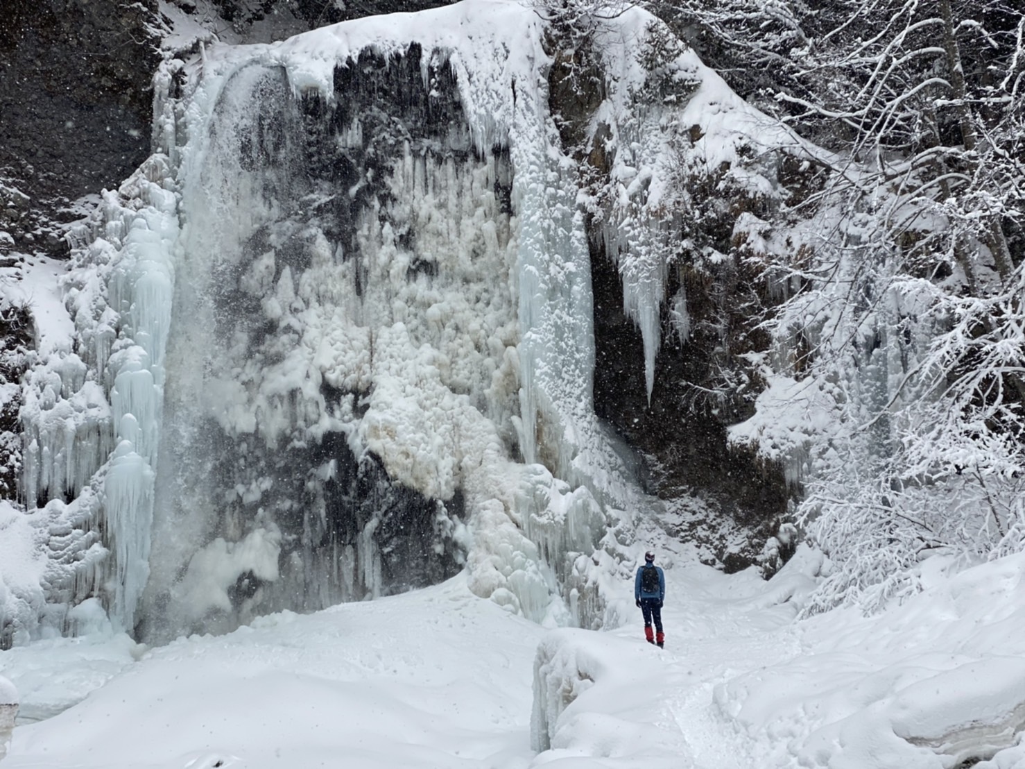 Photo Credit: George Goldade, 2020 Person exploring a snow-scape, glacier, entry of a cave