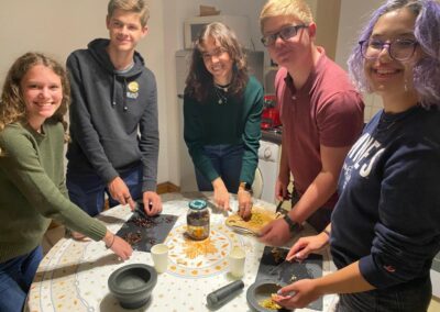 Students around a table mixing ingredients while taking a cooking class