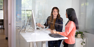 two women working at stand-up desk