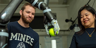 professor and student working on robot arm