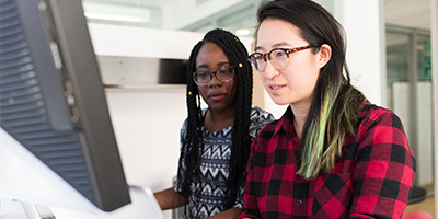 two women working on computers