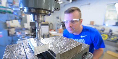 student workin with large tabletop drill