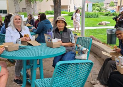 Women's Community Alliance members seated at picnic tables