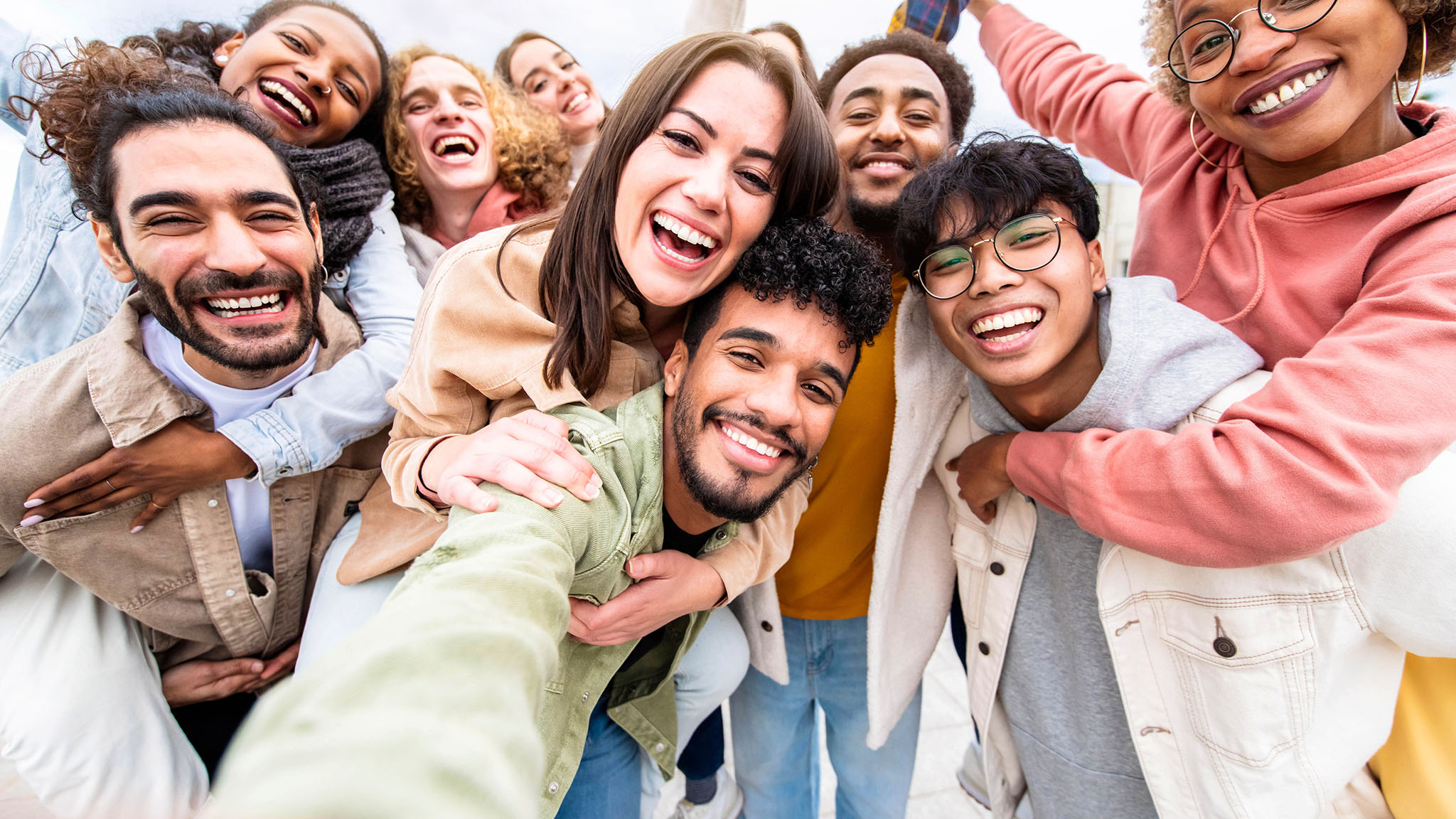 Multiracial friends group taking selfie portrait outside 