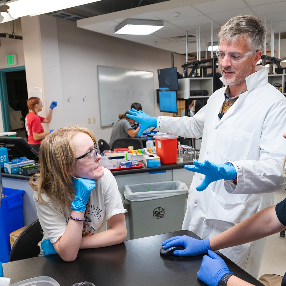 Professor teaching students in a research lab