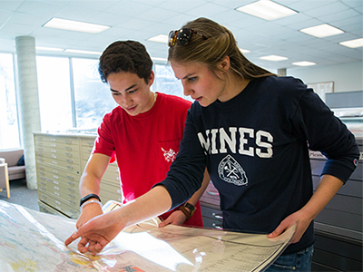 two students reviewing map at library