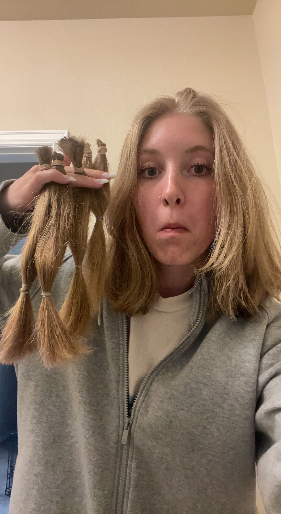 Student holding bunches of recently cut hair