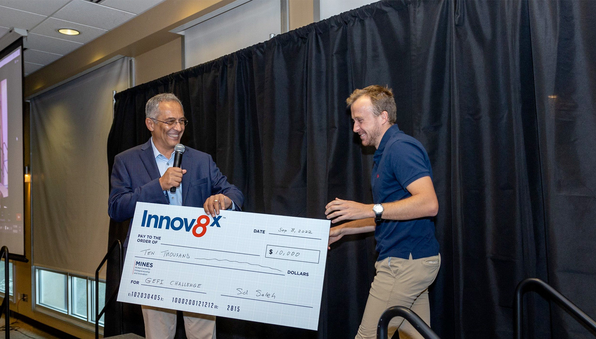 Dr. Sid Saleh presenting a check