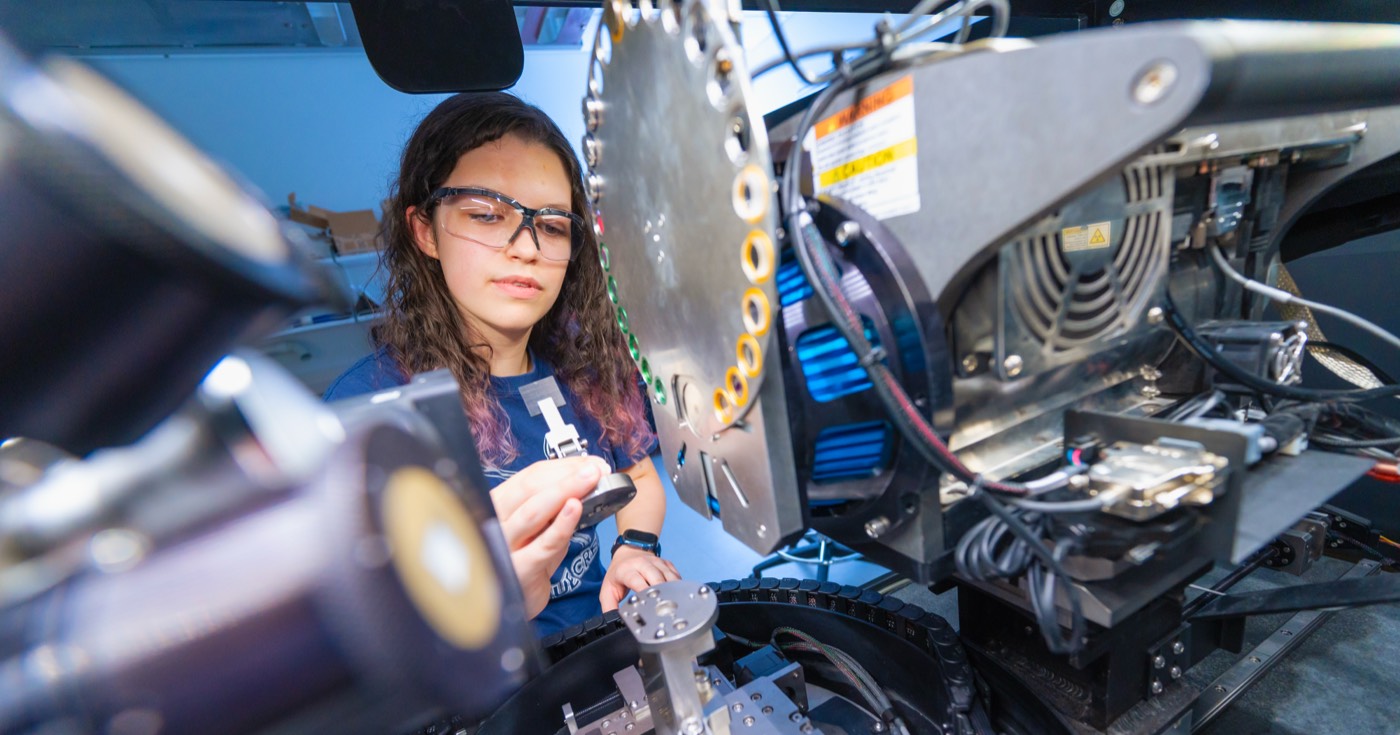 A student working with advanced laboratory machinery and instrumentation during an engineering research project.