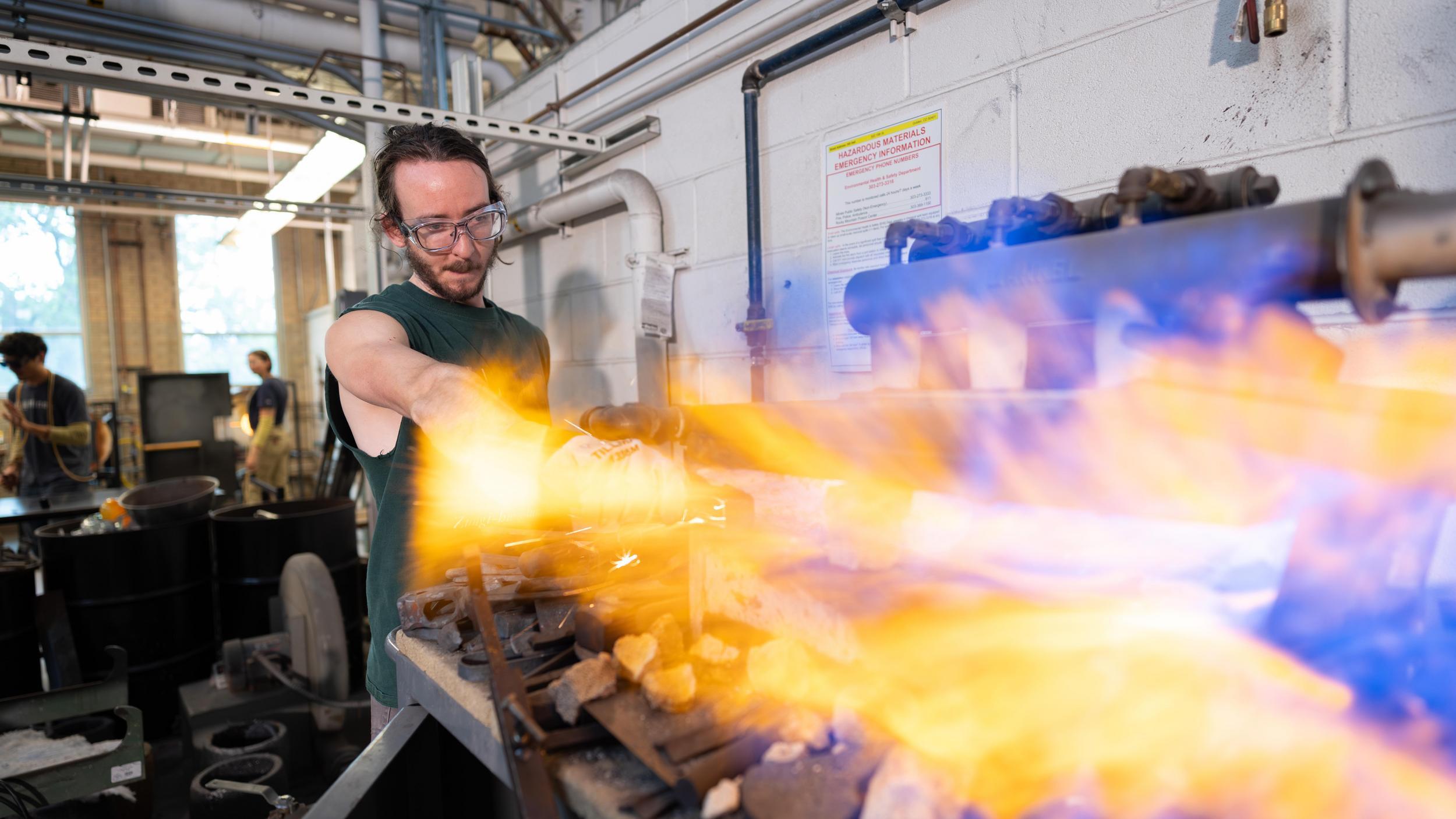 A Metallurgical and Materials Science student operates the furnace at Hill Hall Hot Shop.