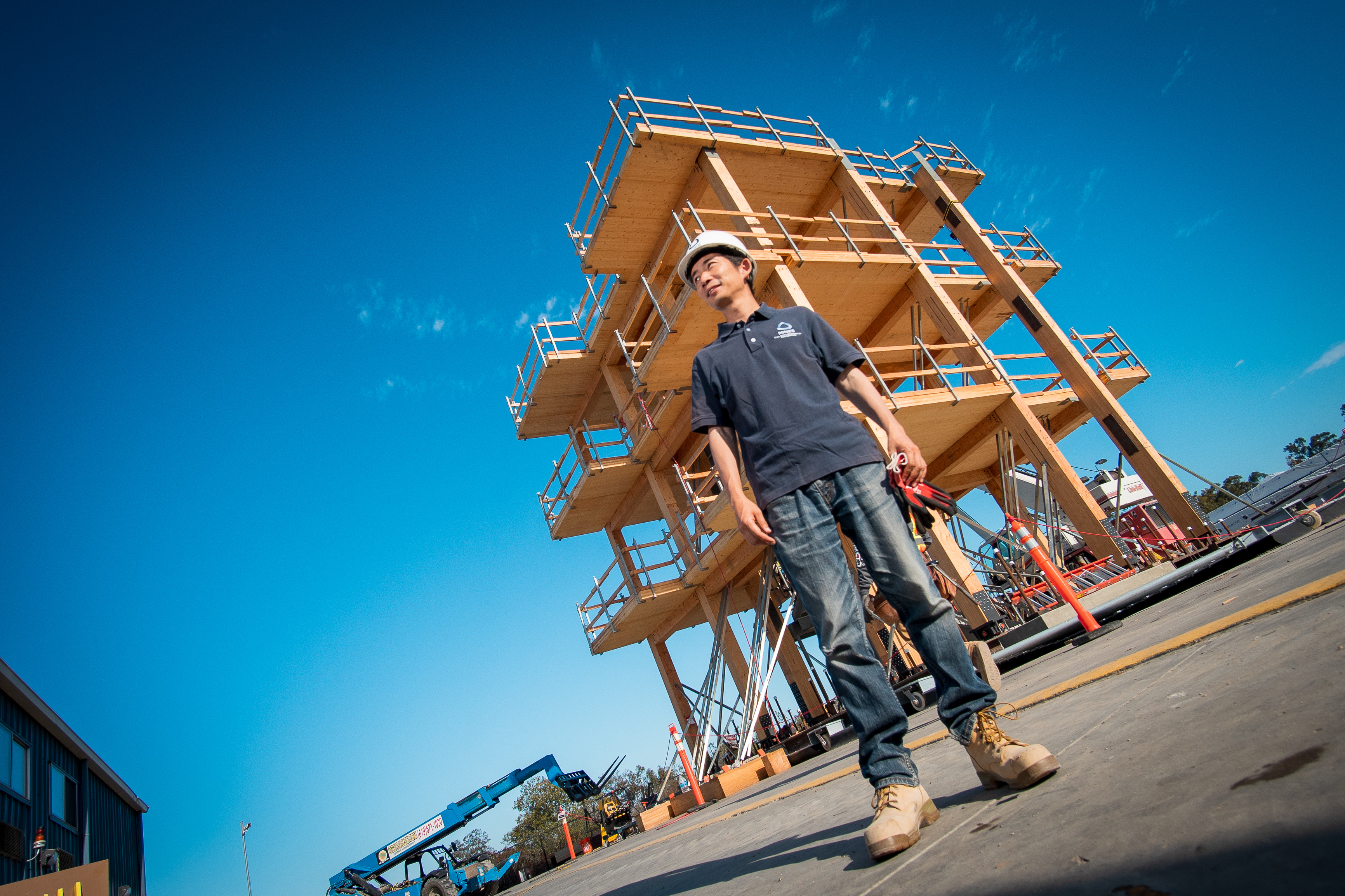 Shiling Pei, associate professor of civil and environmental engineering at Mines, poses during the construction of the 10-story mass timber building on the outdoor shake table at the University of California San Diego. (Photo by David Baillot/University of California San Diego)