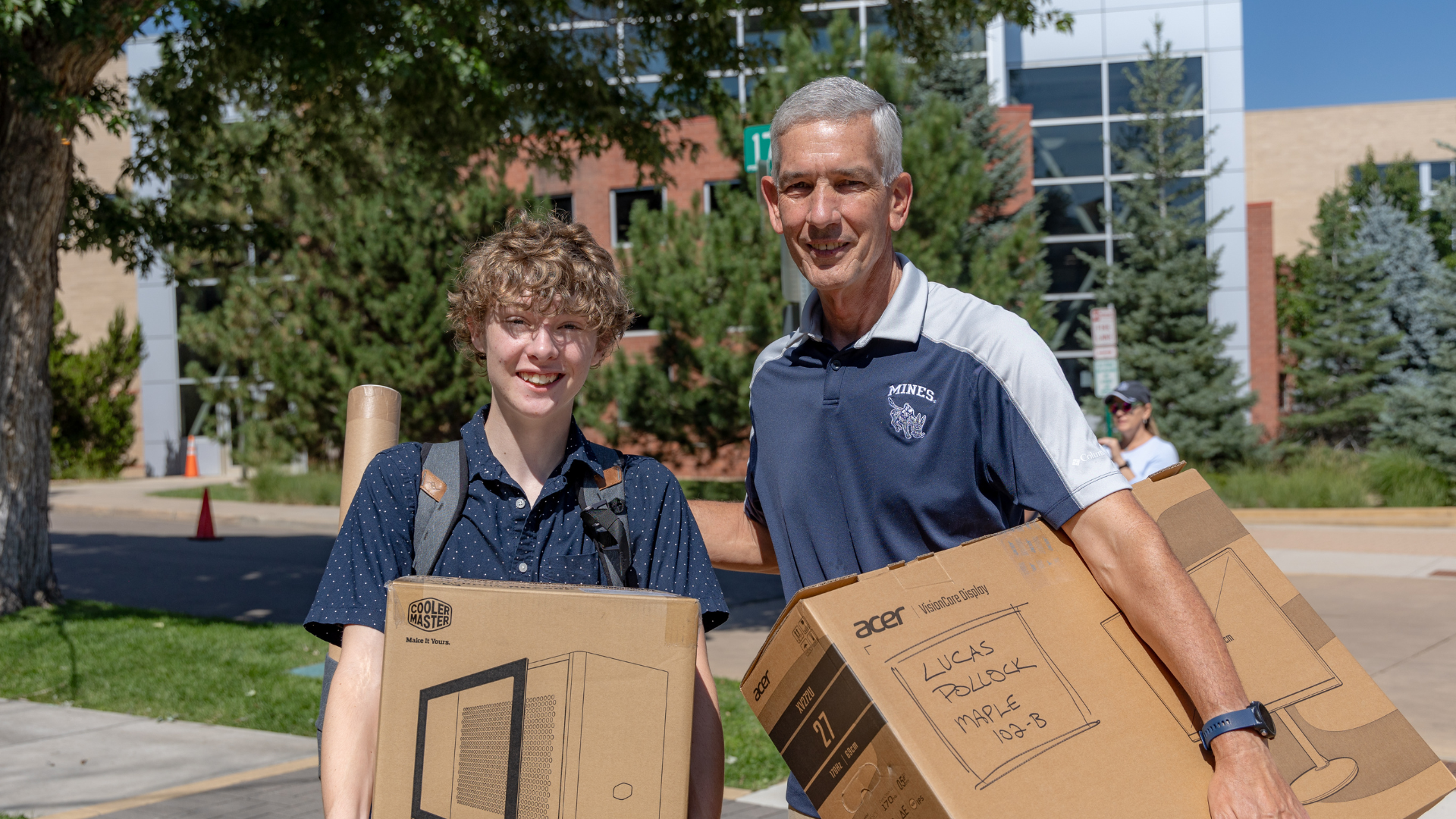 Two students pose while helping move first year students into campus