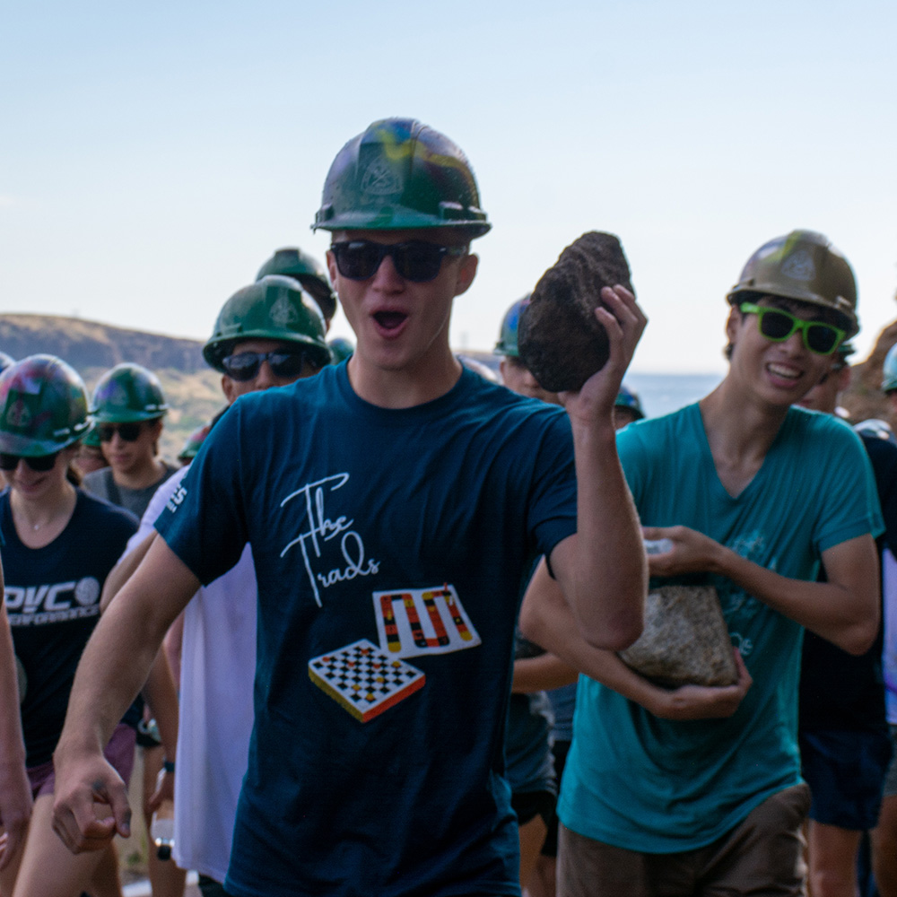 Students posing for a picture with their rocks while climbing up to the M.