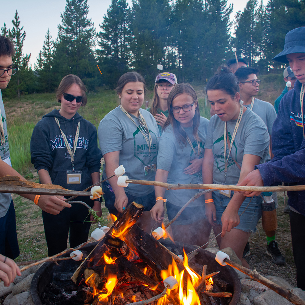 Students at Oredigger Camp posing at the fire camp with smores. 
