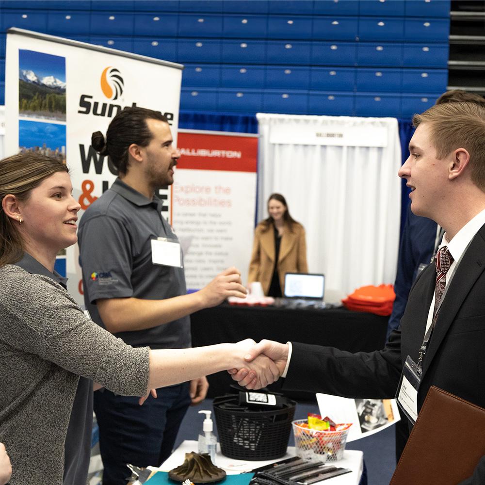 A student and employer shaking hands at career fair