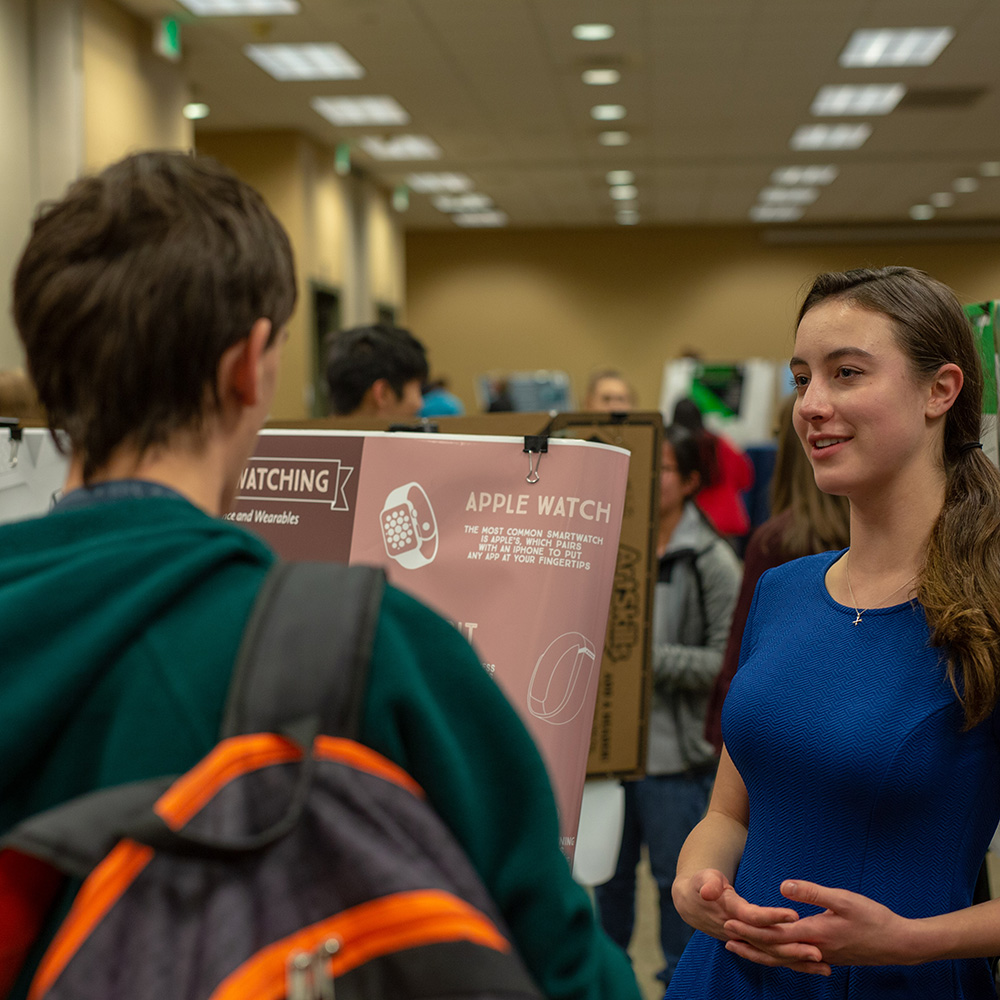 A student presenting their research to an audience.