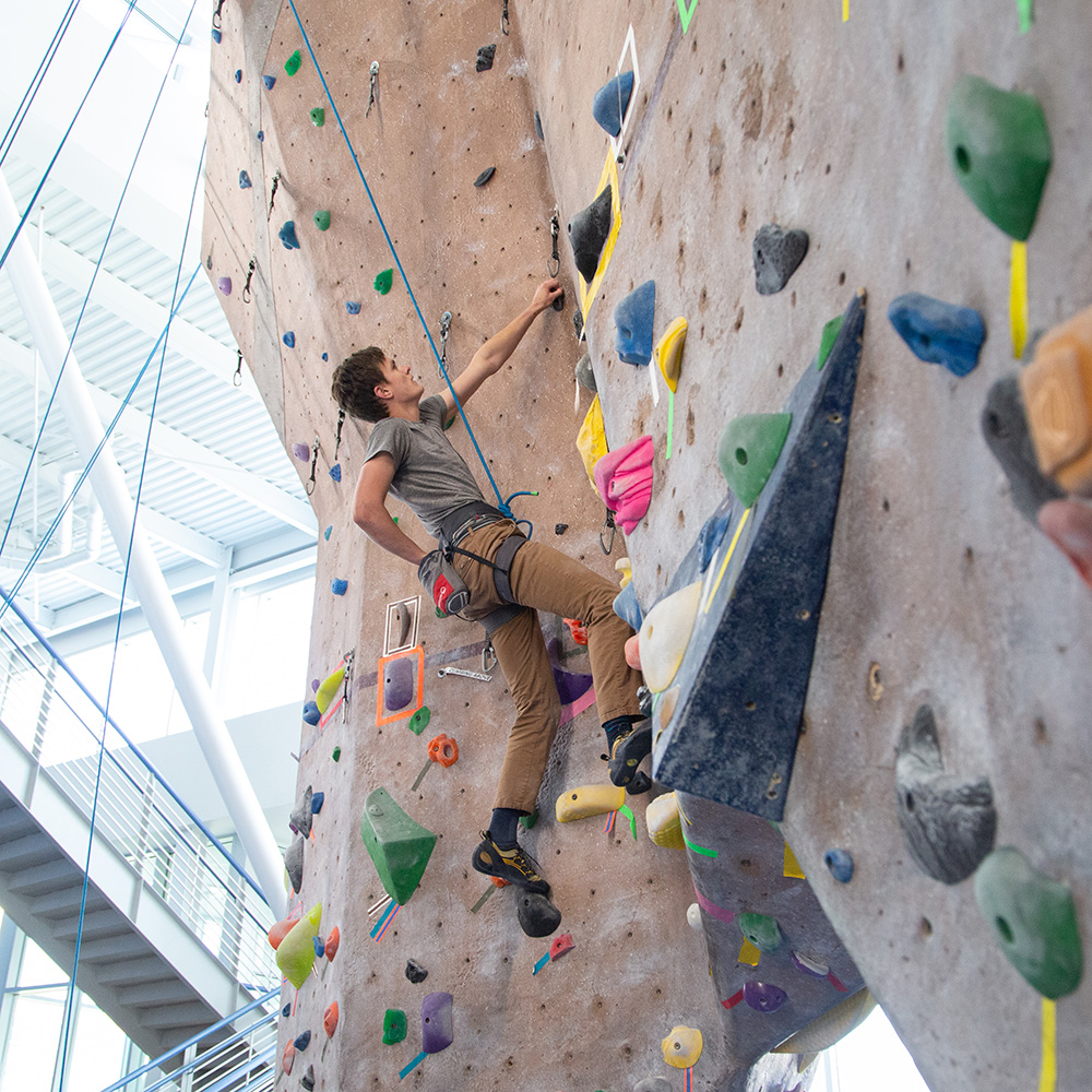 Student using the rock wall in the recreation center.