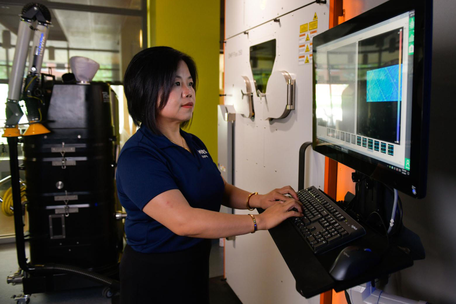 Researchers operating 3-D machine
