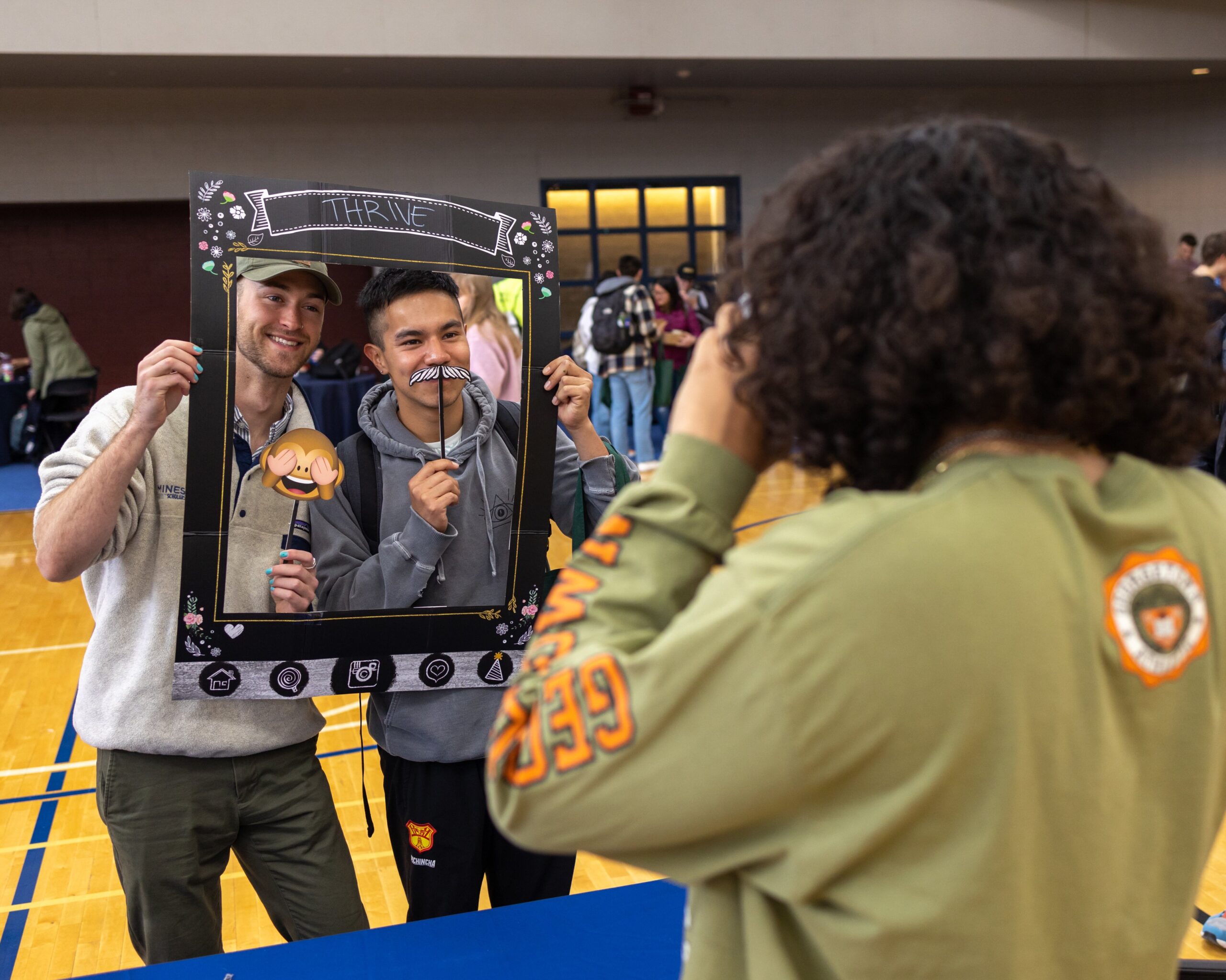 Students get their picture taken with silly props at the "Thrive" booth.