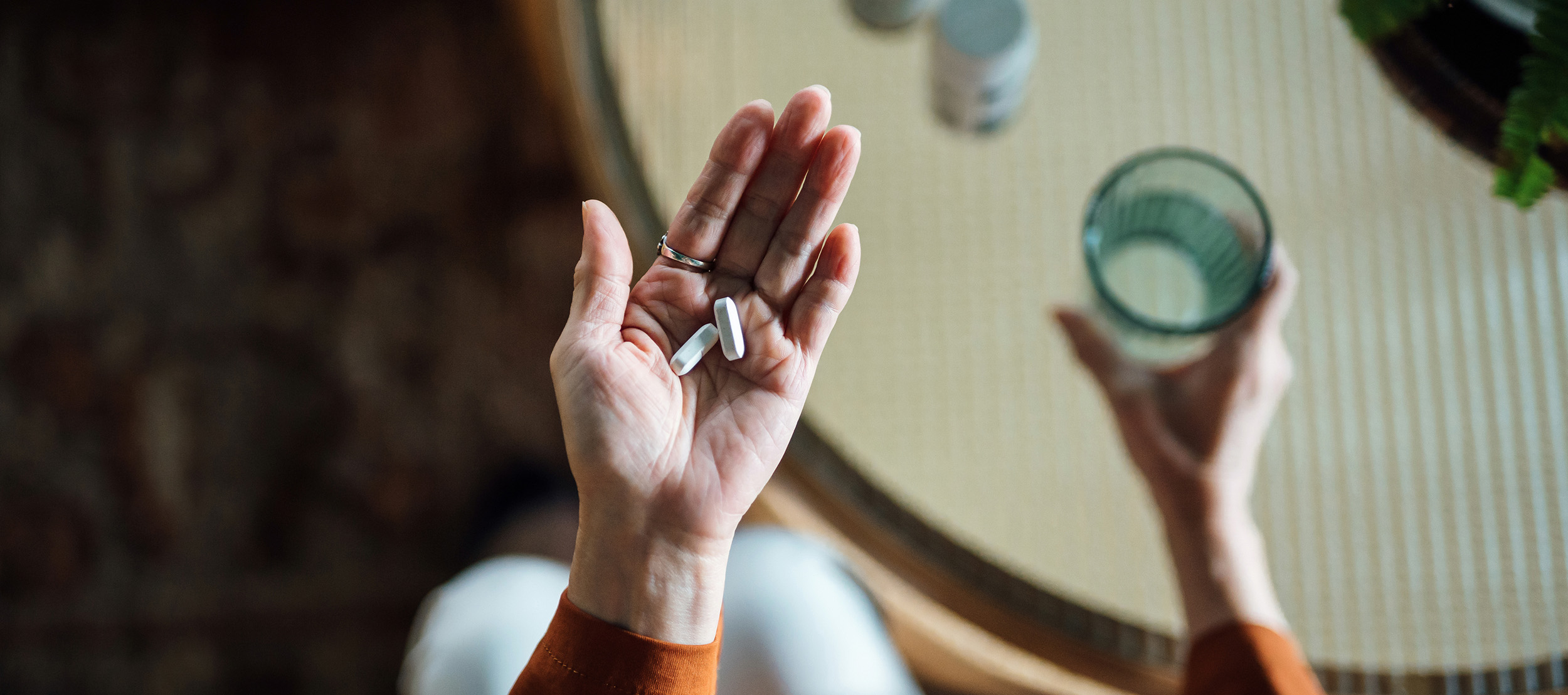 A women holding some medication with water in her hand