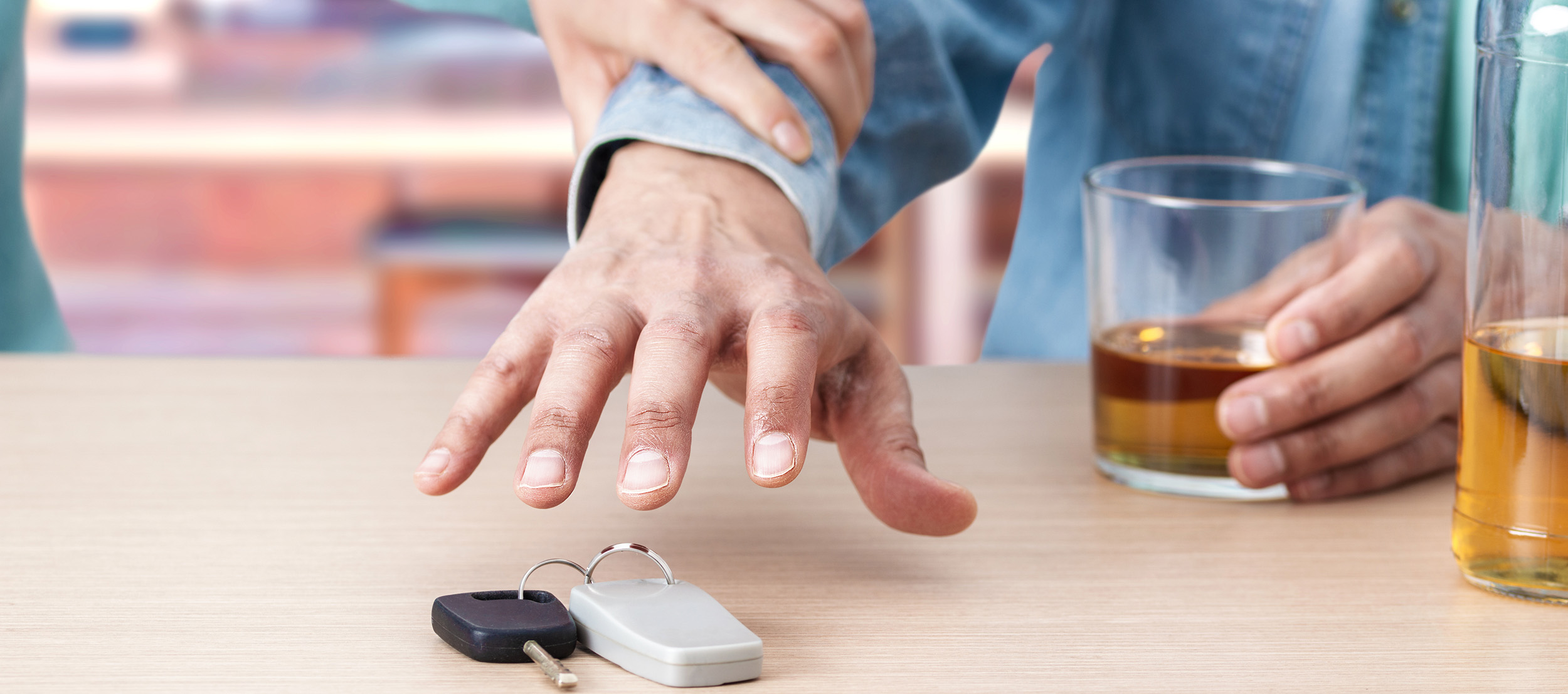 A person stopping his friend from reaching for his car keys while drinking.