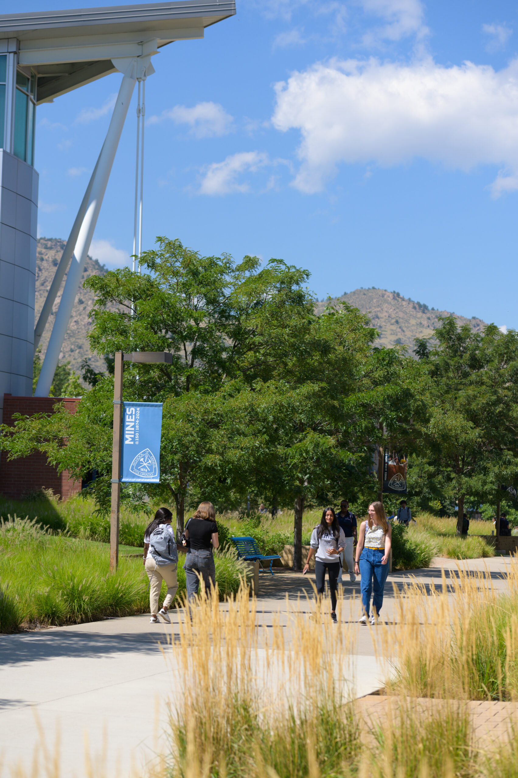 A group of students walk past the Rec Center in summer.