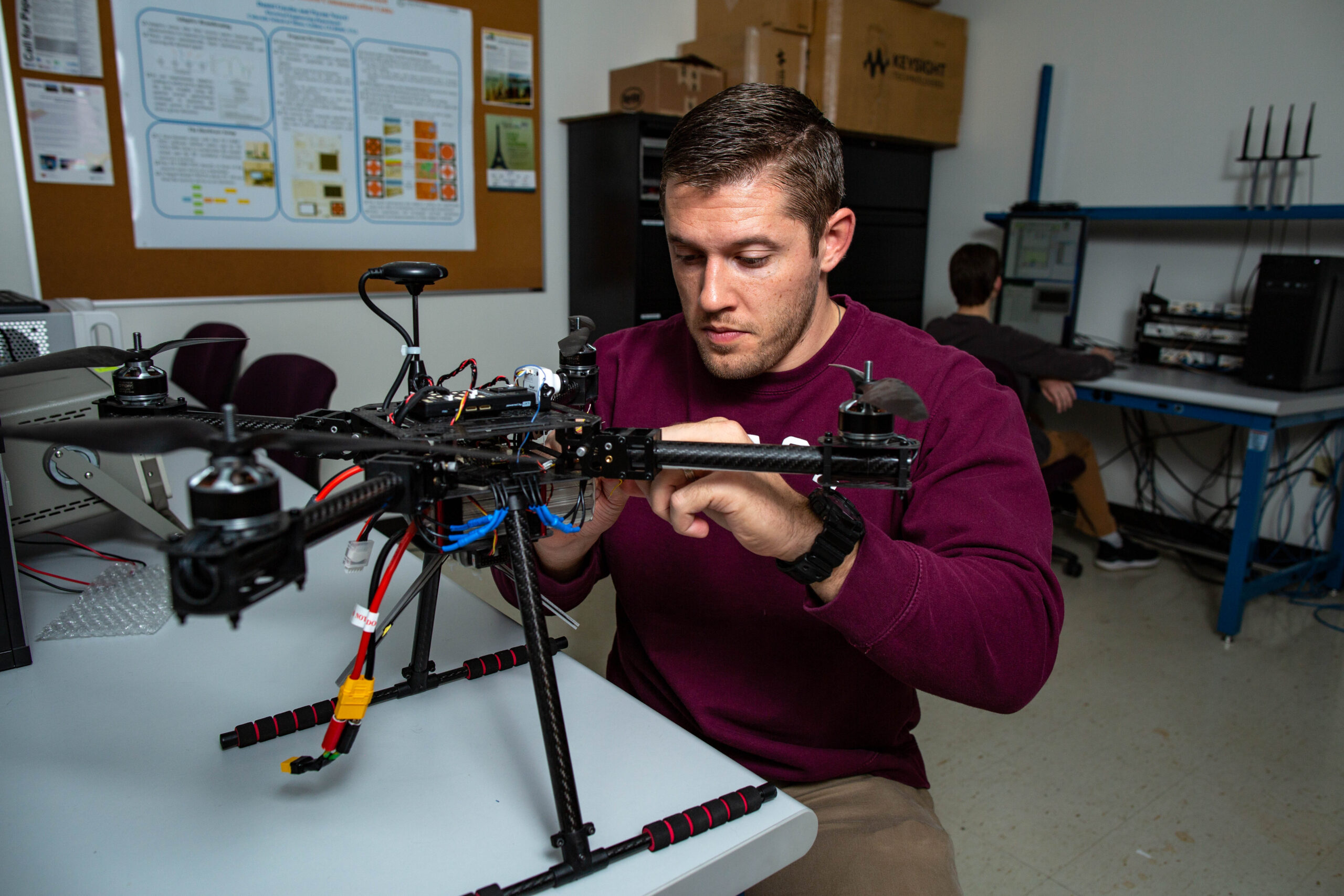 Student works on wiring on a drone.