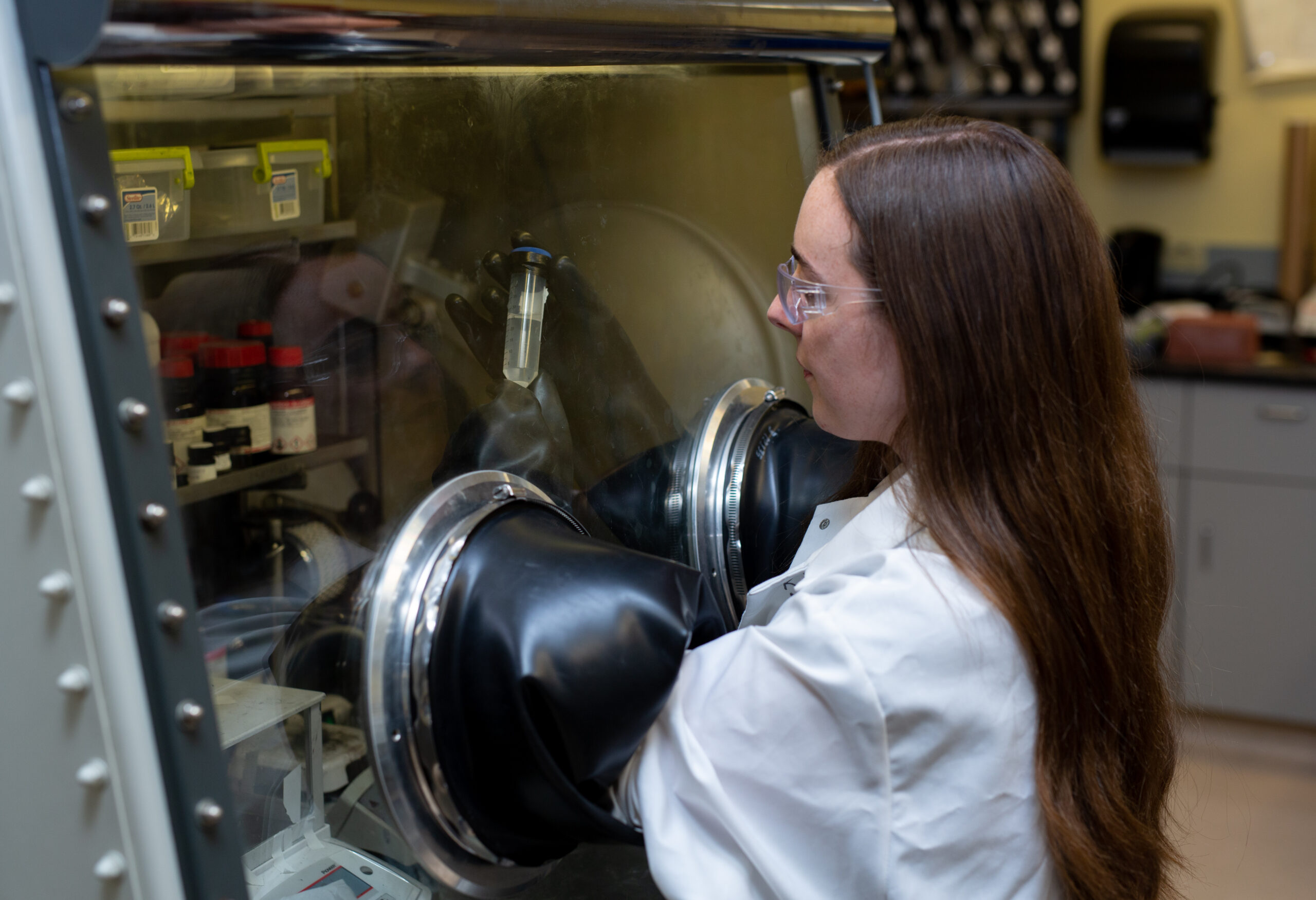 Student removing chemicals from a refrigeration unit.